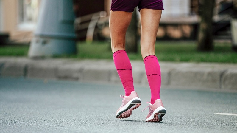 female wearing compression socks while running