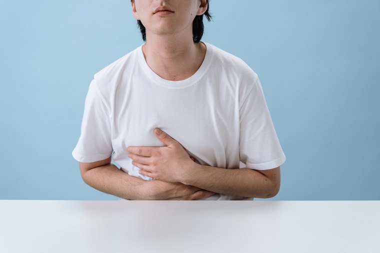 picture of person holding his stomach on a blue background