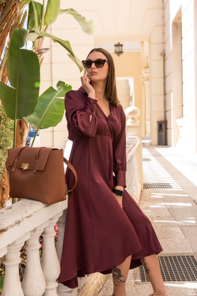 woman wearing brown midi dress with brown bag and sunglasses