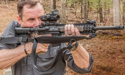 a man holding a gun with a rifle sling